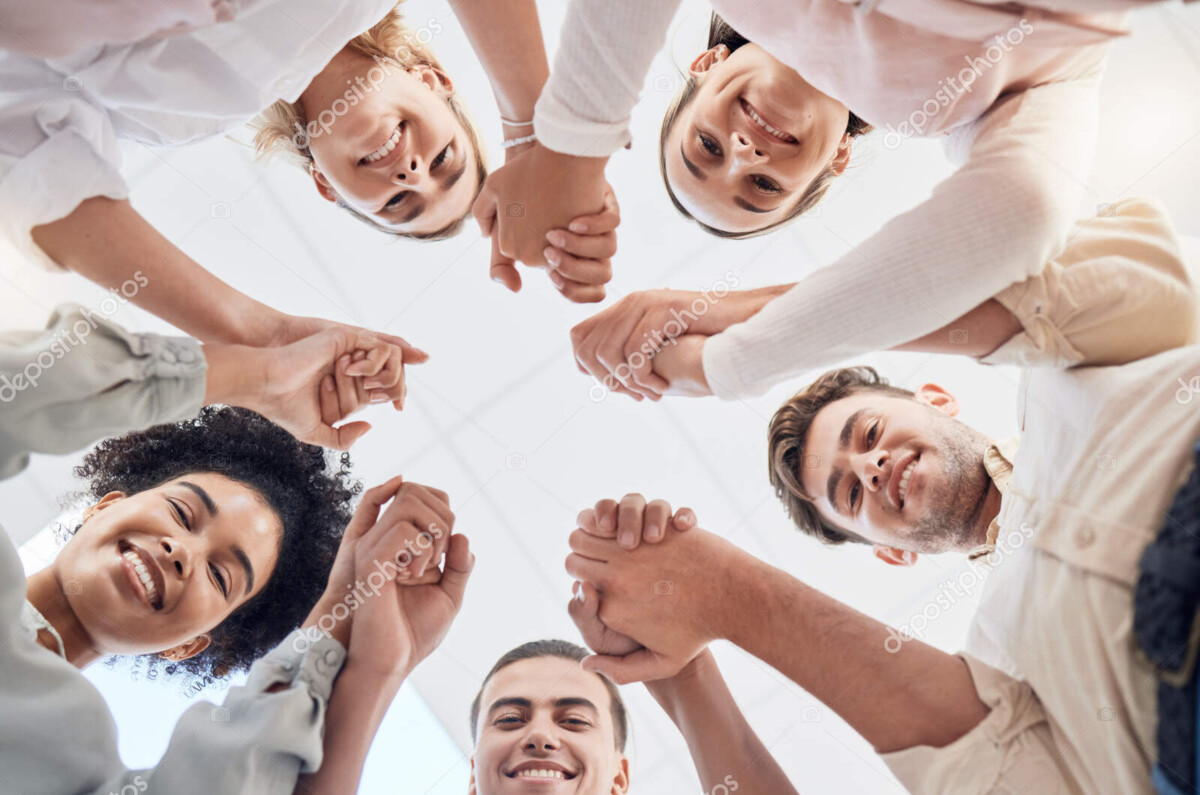 teamwork, support and collaboration of happy employees with diversity, synergy and trust holding hands and looking down. men and women team building circle for mental health mission in workplace